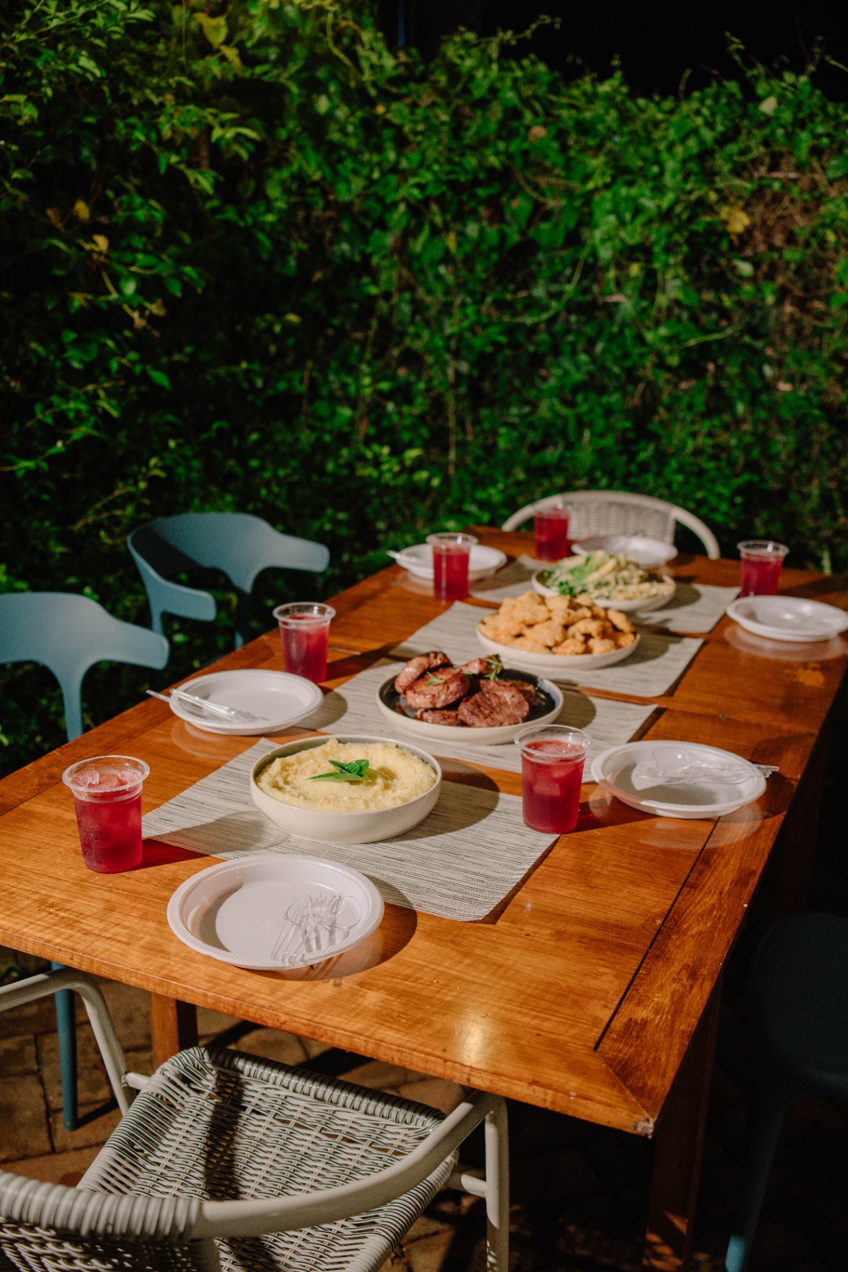 Outdoor dinner table set against greenery
